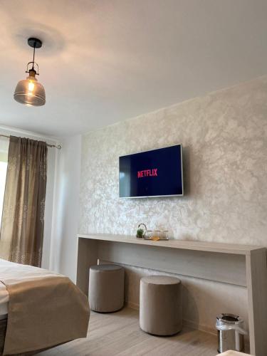a bedroom with a tv on a wall with stools at Pensiunea Maria in Durau
