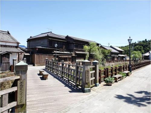 a wooden walkway with benches and a building at Tabino Hotel Kashima in Kamisu