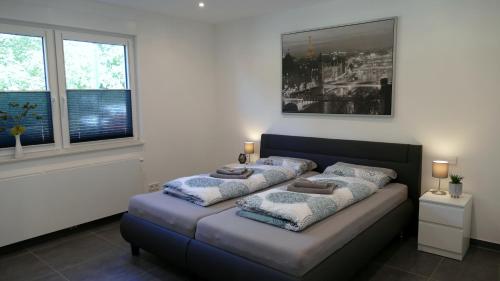 a bed with two pillows on it in a room with windows at Luxury Apartment Weingarten in Weingarten (Karlsruhe)