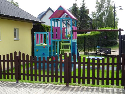 une aire de jeux derrière une clôture dans l'établissement Willa Global komfortowe pokoje nad morzem, à Jastrzębia Góra