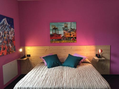 a bedroom with purple walls and a bed with two pillows at B&B Pinabel in Bezzecca