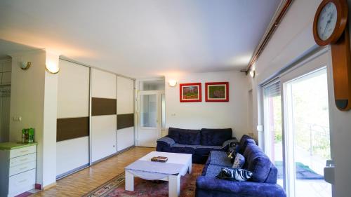 a living room with two blue couches and a table at Neretva River Guesthouse in Konjic