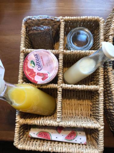 a wicker basket with a bottle of wine and a glass at Karensdal B & B in Uldum