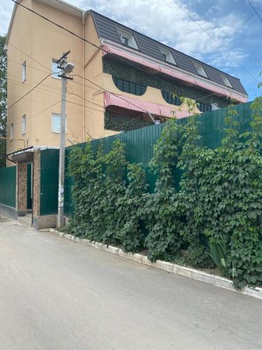 a building with a green hedge next to a street at Міні-готель "Кімната Комфорт" in Odesa