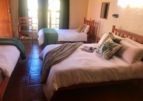 a room with three beds in a room at Old Transvaal Inn Accommodation in Dullstroom