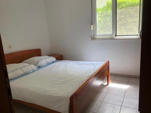 ein Schlafzimmer mit einem Bett in einem Zimmer mit einem Fenster in der Unterkunft Apartment-Villa Vesna in Privlaka