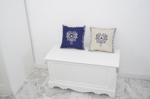a white bench with two pillows on it at I Citri in Taranto