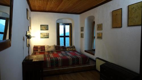 a bedroom with a bed and a window in it at The old olive mill house in Aegae