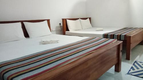 twee bedden naast elkaar in een kamer bij Umaya Holiday Home in Anuradhapura