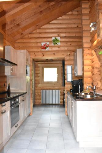 cocina grande con paredes y techos de madera en Le Chardonneret, en La Bresse