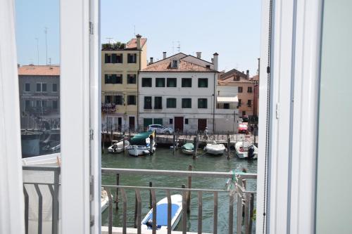 a view of a marina from a window with boats in the water at el Capitan de Mar in Chioggia