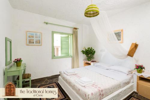 a white bedroom with a bed and a window at Elounda Collection Apartments in Elounda