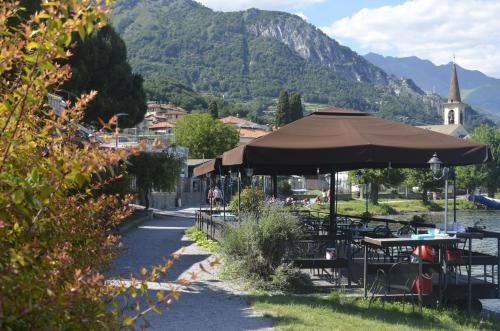 a group of tables and chairs with an umbrella at AnMa Cottages The Secret Garden in Pianello Del Lario