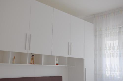 a white kitchen with white cabinets and a window at el Capitan de Mar in Chioggia
