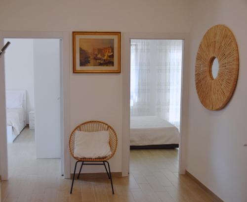 a chair in a room with a bed and a mirror at el Capitan de Mar in Chioggia
