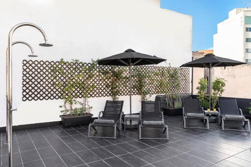 a patio with chairs and umbrellas on a building at Nin&Bau Sarri 2 in Athens