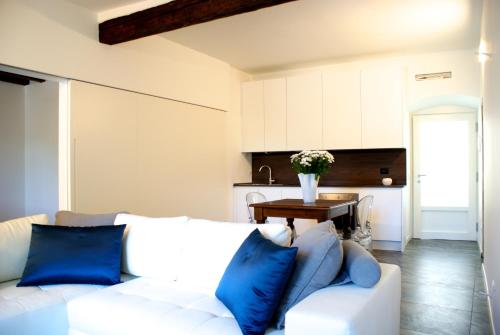 ein Wohnzimmer mit einem weißen Sofa und blauen Kissen in der Unterkunft Albergo Diffuso Vulcano Village in Castro