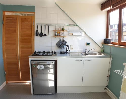 a small kitchen with a stove and a sink at Be.Cosy in Brussels