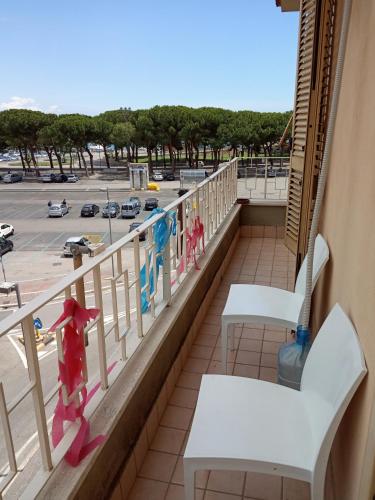 a balcony with white chairs and a parking lot at holiday house MAURIZIO in Formia