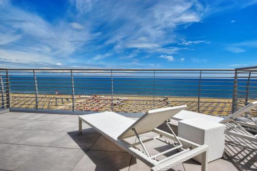 a balcony with chairs and a view of a beach at Hotel Delle Nazioni - Adults Only in Caorle