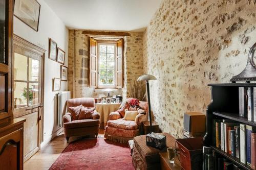 a living room with two chairs and a table at 14th Century Priory in Pressigny in Pressigny
