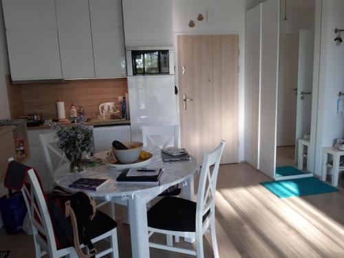 a kitchen with a table and chairs in a room at Lazurowy Apartament in Kołobrzeg