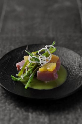 een zwarte plaat met eten op tafel bij Le Boutique Danang in Da Nang