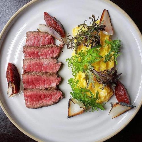 een witte plaat met vlees en groenten bij Le Boutique Danang in Da Nang