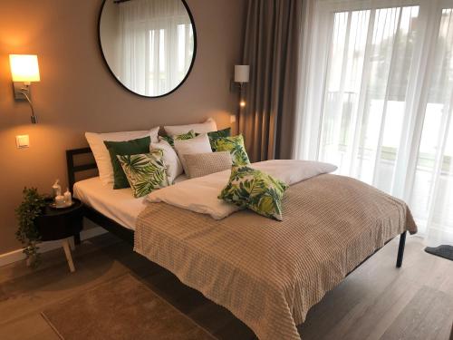 a bedroom with a bed and a mirror and a window at Apartamenty Pod Gwiazdami in Ustroń