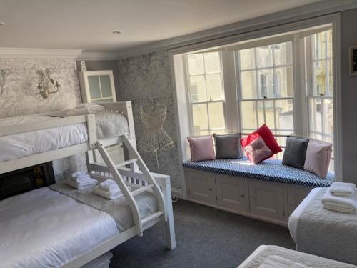 a bedroom with two bunk beds and two windows at Parisien Parfumerie in Brighton & Hove