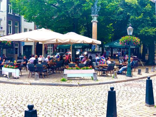 a group of people sitting at tables and chairs in a park at accademia00 in Maastricht