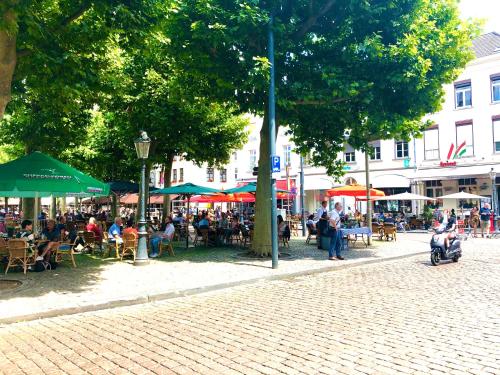 a group of people sitting at tables and umbrellas on a street at accademia00 in Maastricht