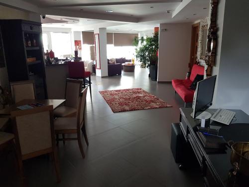 sala de estar con sofá rojo y mesa en Crystal Aura, en Paralia Katerinis