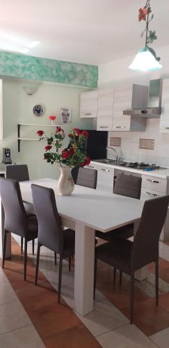 ロッカルメーラにあるappartamento Claudiaのキッチン(テーブル、椅子、花瓶付)