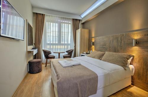 una habitación de hotel con una cama grande y una mesa en Arus Hotel en Eskisehir