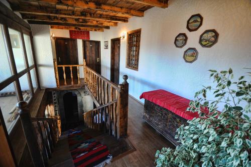 a room with a staircase with a red couch and a plant at Hotel Tradita in Shkodër