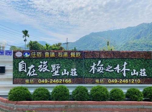 a sign with chinese writing on a wall with mountains in the background at 自在旅墅山莊 in Guoxing