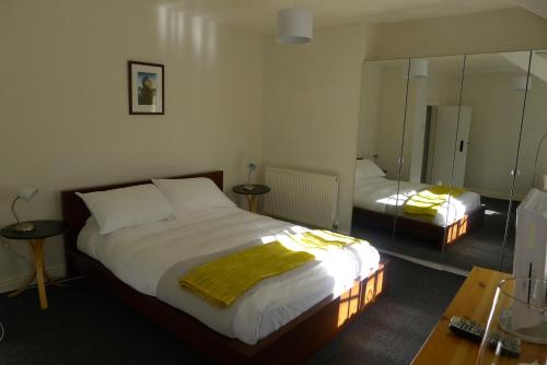a bedroom with a large bed and a mirror at Totters townhouse in Caernarfon