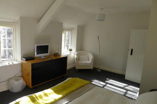 a bedroom with a desk with a television and a chair at Totters townhouse in Caernarfon