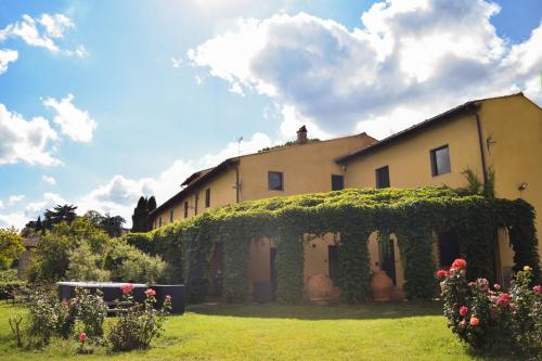 a house with ivy growing on the side of it at Tenuta Massabò in San Casciano in Val di Pesa