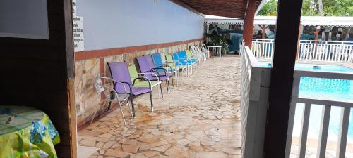 a row of chairs sitting next to a swimming pool at Domaine De Titine in Bonneville