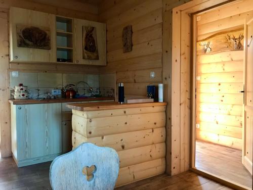 a kitchen with a blue chair in a log cabin at Serce Beskidu Niskiego in Świątkowa Mała