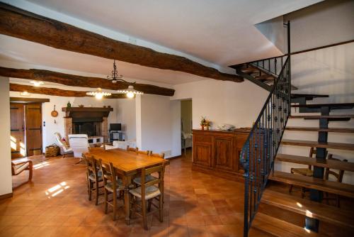 ein Esszimmer mit einem Holztisch und einer Treppe in der Unterkunft Agriturismo Il Corniolo in Castiglione di Garfagnana