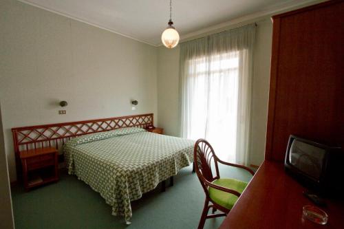 1 dormitorio con 1 cama con mesa y ventana en Albergo Amici, en Varese Ligure