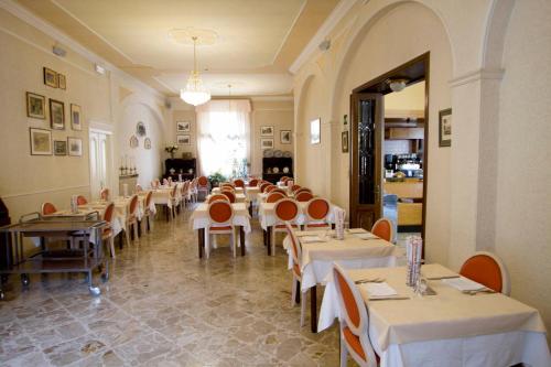 uma sala de jantar com mesas e cadeiras num restaurante em Albergo Amici em Varese Ligure