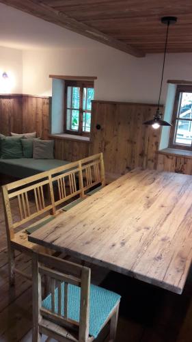 un grande tavolo in legno in una stanza con divano di Plötzhof a Hof bei Salzburg