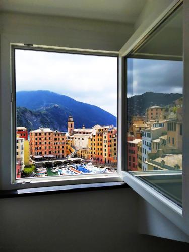 a window in a room with a view of a city at La mansarda sul Porto in Camogli