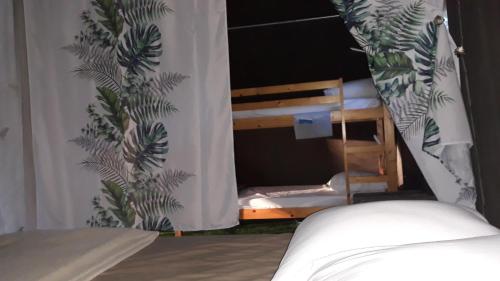 a bedroom with a bed and a window with a plant at Le Bivouac et sa piscine in Saint-Victor-de-Malcap