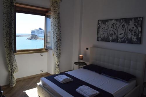 a bedroom with a bed and a large window at B&B Il Veliero in Civitavecchia