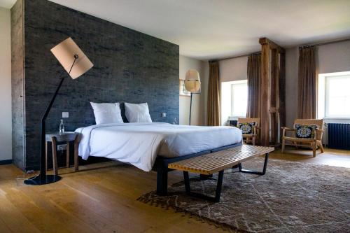 a bedroom with a large bed with a brick wall at Ferme du Château in Anthenay